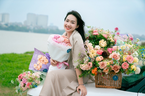 Họa sĩ Phan Anh Thư mang hoa phủ bãi sông Hồng