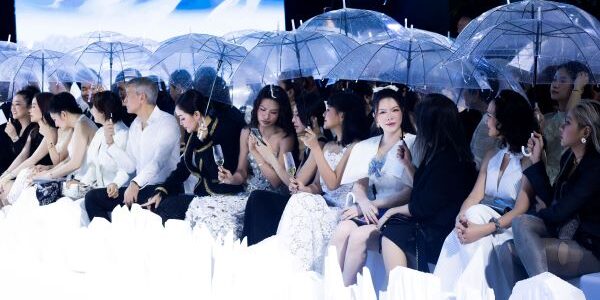 Lý Nhã Kỳ che ô xem show thời trang giữa trời mưa